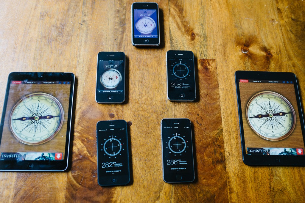 Seven different iOS devices running compass applications, all showing similar results for true north.