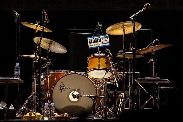 Charlie Watts’s drum kit, on stage, with a “closed” sign hanging from it.