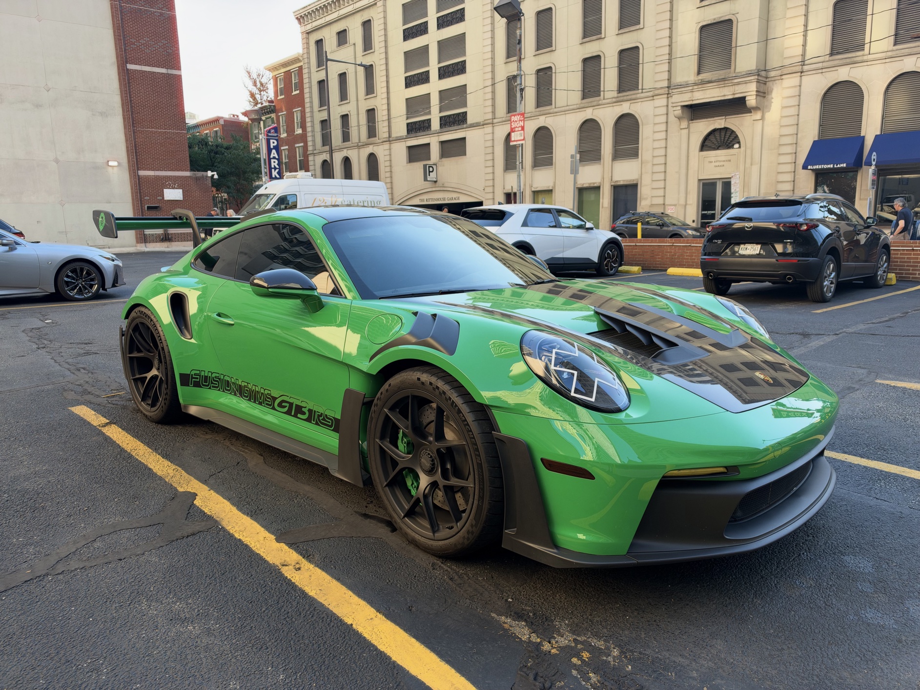 A bright green Porsche 911 GT3 in a parking lot.