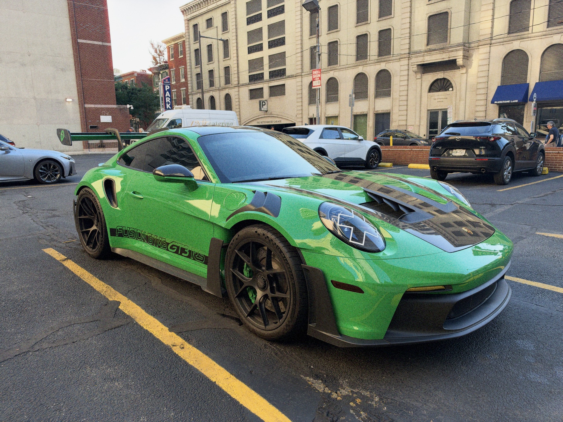 A bright green Porsche 911 GT3 in a parking lot.