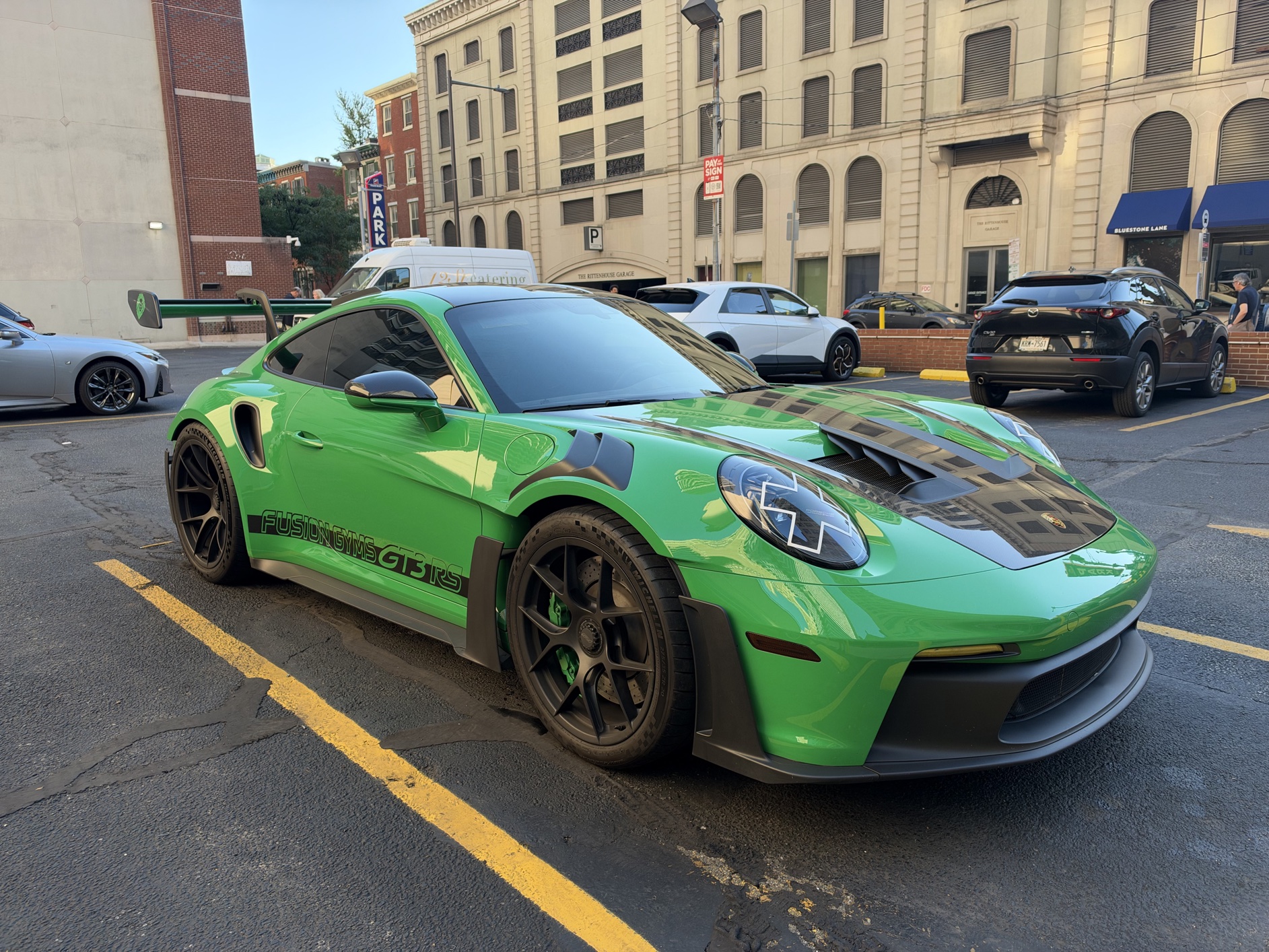A bright green Porsche 911 GT3 in a parking lot.